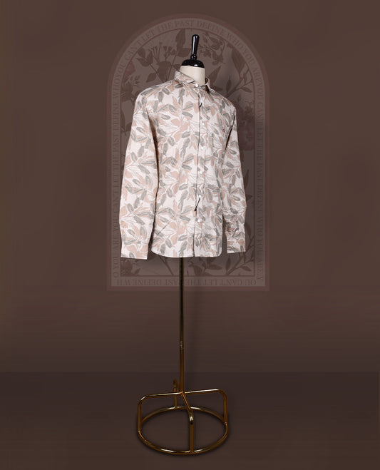 Cream colored shirt in soft cotton, featuring an all over leaf print in subtle earthy tones, Designed with a classic collar and roll up sleeves, it offers a perfect balance of tradition and ease.