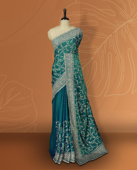 Sky blue colour velvet chiffon designer saree in elegant two tone shades, featuring light gold zari, kodi work with handwoven style thread aari & dori embroidery work, Swarovski stone work and all over motifs, comes with matching blouse.