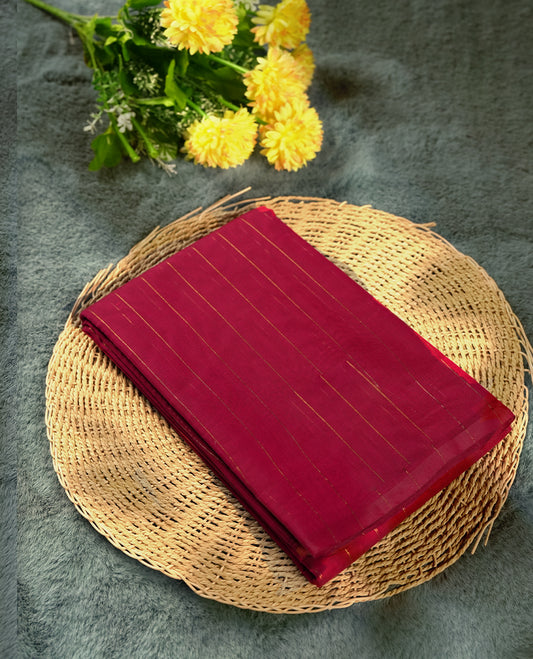 Burgundy colour silk cotton saree featuring with full of delicate vertical copper zari lines on the body & rust orange colour contrasted border, Crafted without a border for a classy touch, Comes with a matching blouse.