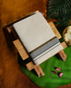 Cream colour cotton dhoti adorned with a refined grey border accentuated by sleek black lines and a touch of golden zari, blending traditional elegance with subtle modern charm for festive and cultural occasions.