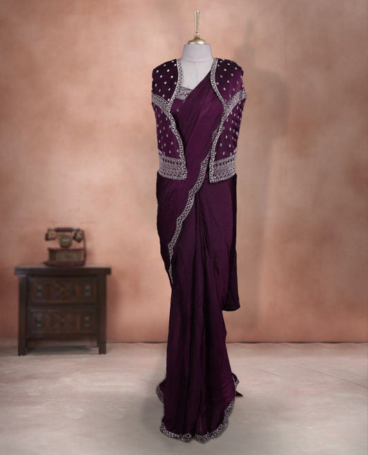 Elegant Wine Colour ready to wear saree adorned with rich silver zari and bead embroidery along the border and pallu, paired with a heavily embellished matching blouse for a grand festive look.