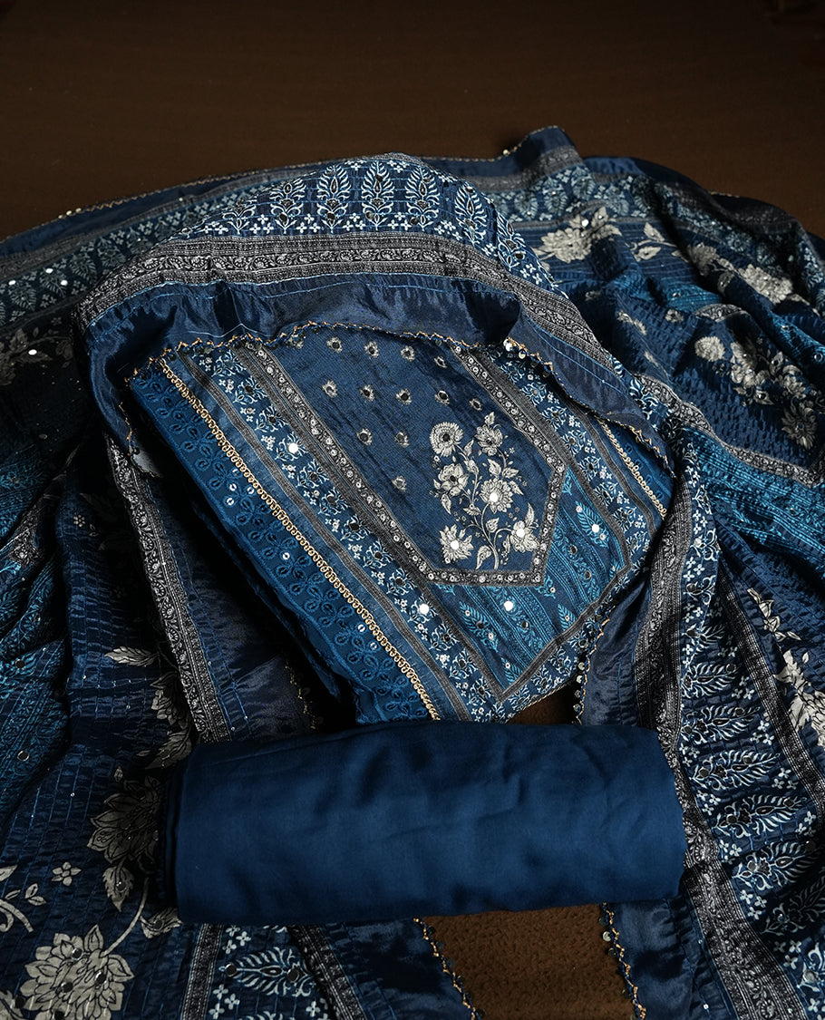 Dark Blue colour churidhar material featuring Mirror and thread embroidery, foral print pattern on the self colour front panel, floral digital printed dupatta with elegant border, and matching plain bottom
