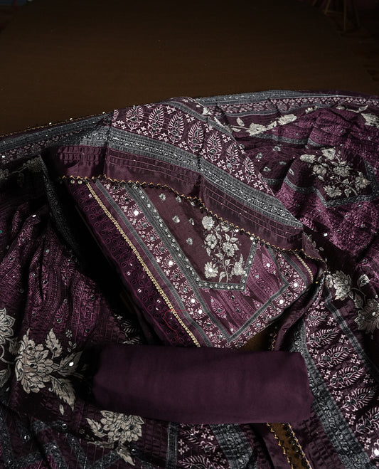 Dark purple colour churidhar material featuring Mirror and thread embroidery, foral print pattern on the self colour front panel, floral digital printed dupatta with elegant border, and matching plain bottom
