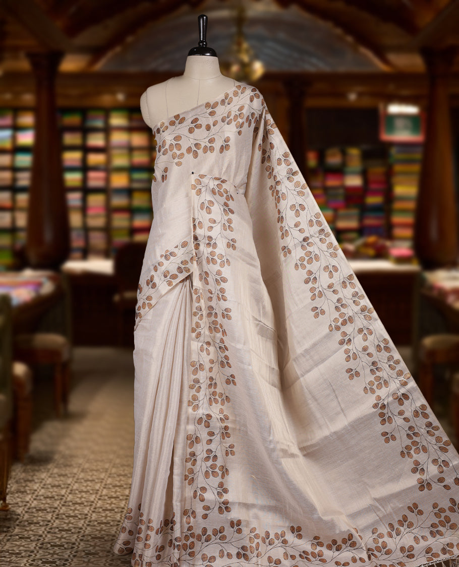Beige colour Semi tissue saree adorned with earthy toned digital leaf prints on the body and an elegant pallu & comes with a matching blouse piece