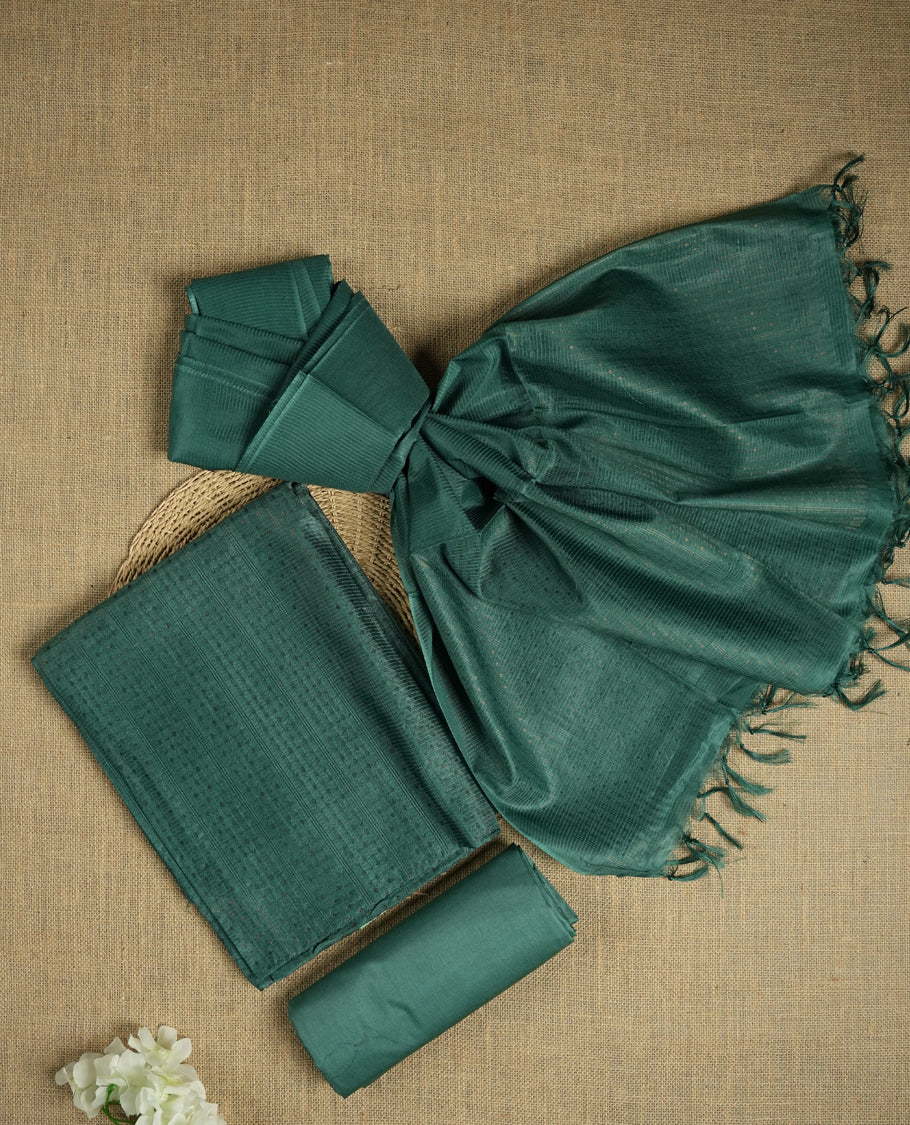 Dark aqua green colour tussar suit material featuring a subtle self copper zari woven small motifs and vertical and stripped pattern on the body, paired with a lightweight matching dupatta with tassel edges and a plain bottom piece.