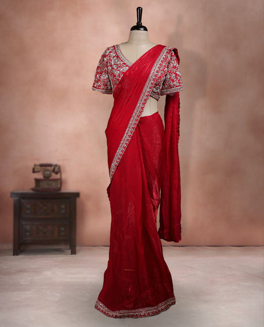 Elegant Bright Red Colour ready to wear saree adorned with rich silver zari and bead embroidery along the border and pallu, paired with a heavily embellished matching blouse for a grand festive look.
