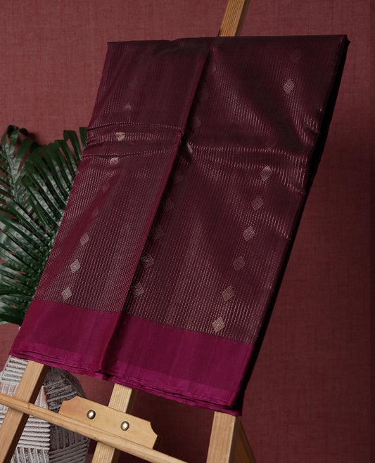 Dark Maroon colour pure Handloom cotton saree featuring fine golden stripes with delicate motifs, paired with a rich zari magenta border for a traditional yet elegant look, perfect for graceful occasions & Comes with matching blouse.