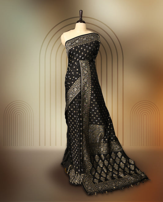 Elegant black Banaras soft silk saree with gold zari buttas on the body, ornate floral zari border, rich woven pallu, and comes with a matching blouse & A timeless drape for festive and formal occasions.