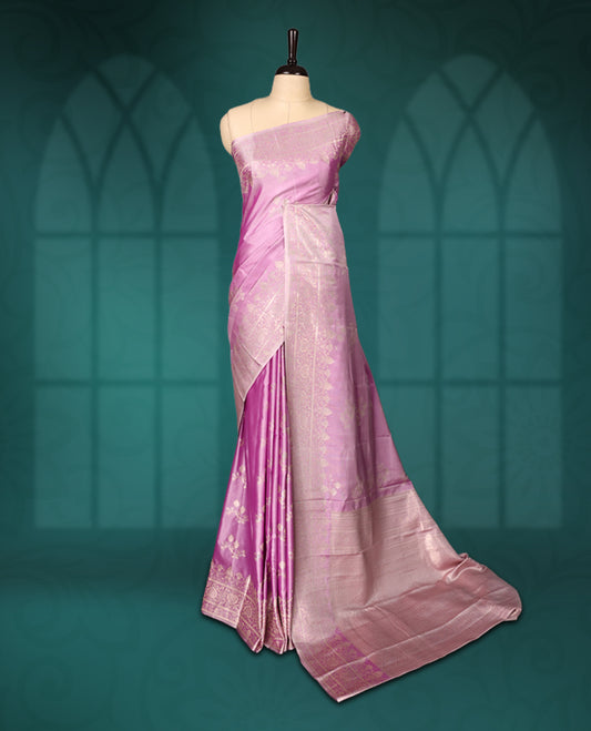 Lavender colour semi silk saree featuring delicate golden zari floral motifs across the body, complemented by a rich self-colour woven border and pallu, paired with a matching blouse.