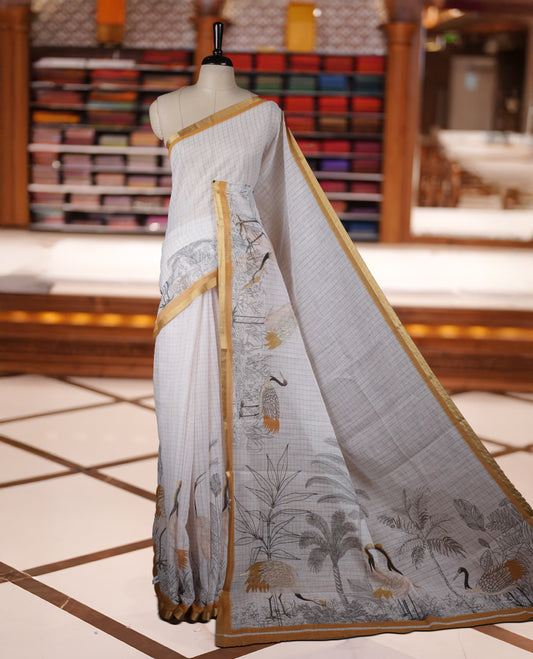 Off white colour Soft cotton saree featuring elegant bird prints along the edges, a stylish checked body, and a beautifully designed yellow border & Paired with a matching blouse piece.