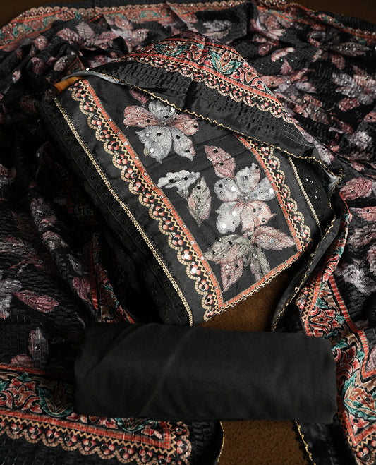 Black colour churidhar material featuring Mirror and thread embroidery, foral print pattern on the self colour front panel, floral digital printed dupatta with elegant border, and matching plain bottom