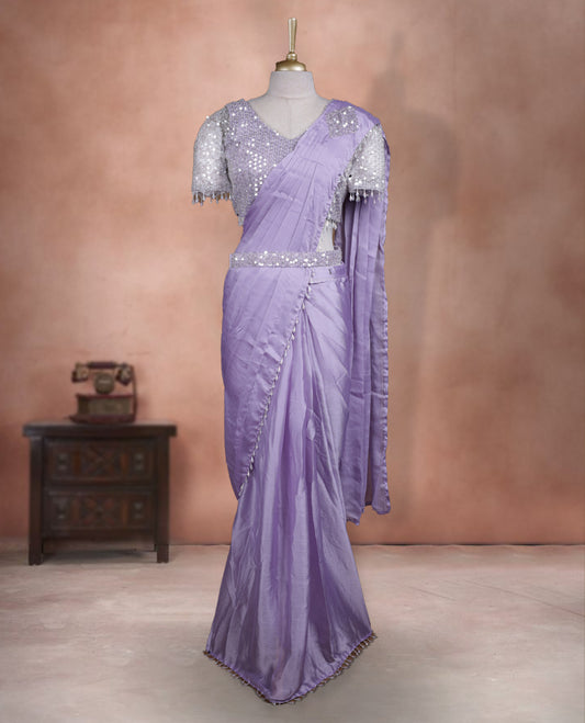 Elegant Lavender Colour ready to wear saree adorned with rich silver zari and bead embroidery along the border and pallu, paired with a heavily embellished matching blouse for a grand festive look.
