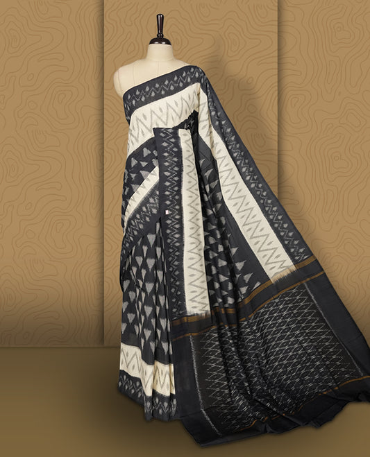 Black and Cream colour Ikkat Pochampally saree adorned with striking grey colour geometric motifs and a contrasting traditional border, The intricately woven pallu adds elegance, making it a timeless drape.