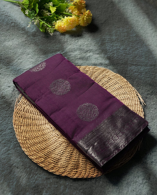 Grape colour silk cotton saree with shimmering silver zari border and intricately woven pallu, blending elegance and tradition. Paired with a matching blouse, perfect for festive celebrations and special occasions.