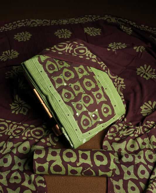 Green and Brown colour cotton churidar material adorned with mirror work on the neckline, featuring traditional tie dye patterns & Comes with a matching printed dupatta and coordinated printed bottom.