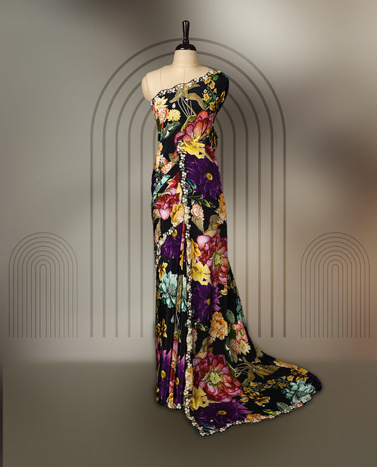 Black pure crepe saree featuring vibrant multi colour floral prints, adorned with delicate cut beads and pearl work along a scalloped border, paired with a matching blouse.