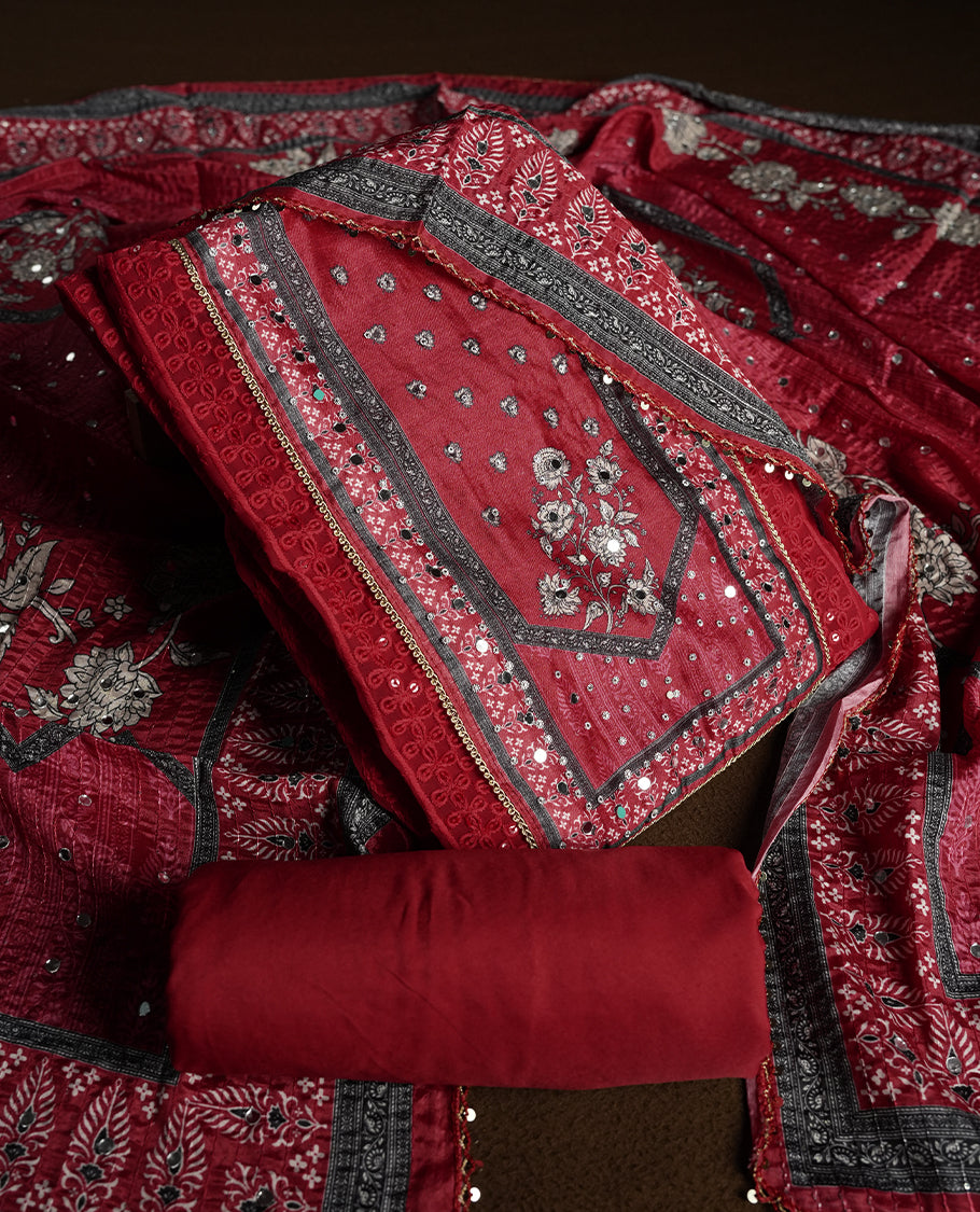 Dark Red colour churidhar material featuring Mirror and thread embroidery, foral print pattern on the self colour front panel, floral digital printed dupatta with elegant border, and matching plain bottom
