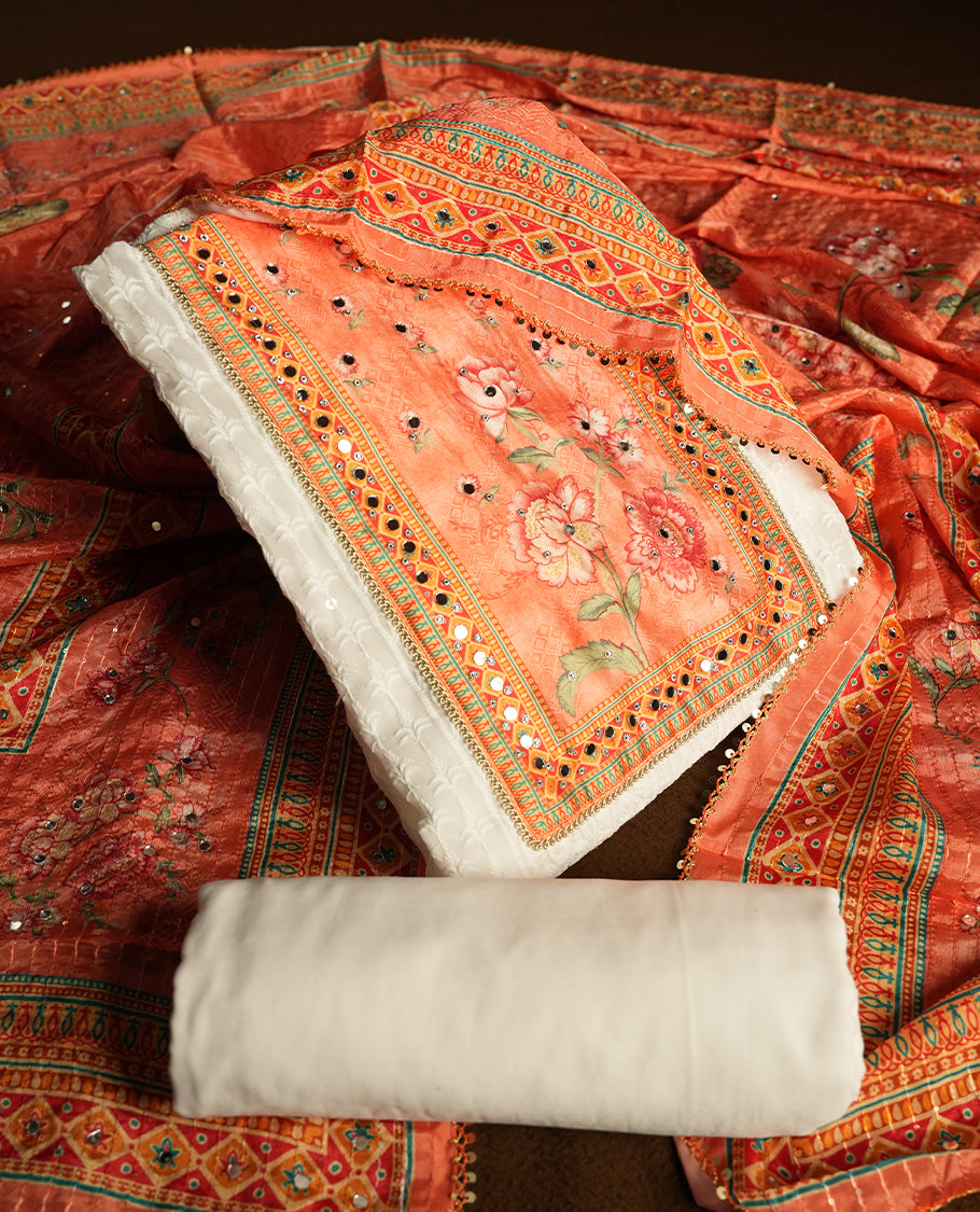 White colour churidhar material featuring Mirror and thread embroidery, foral print pattern on the contrast Orange colour front panel, floral digital printed dupatta with elegant border, and matching plain bottom