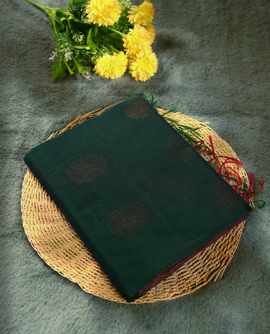 Deep greeen colour soft silk cotton saree adorned with copper zari motifs and a shimmering copper zari border, Enhanced by a beautifully rich maroon colour woven pallu & Comes with a matching blouse piece for a complete look.