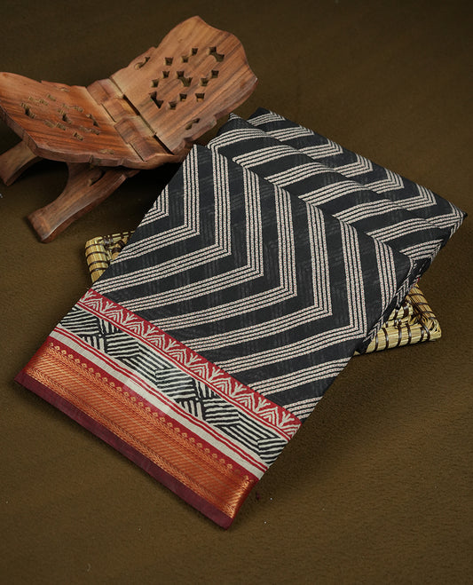 Black colour mixed chanderi cotton saree with ashy white zari body, red and black geometric pallu with floral motifs, gold border, and matching black blouse.