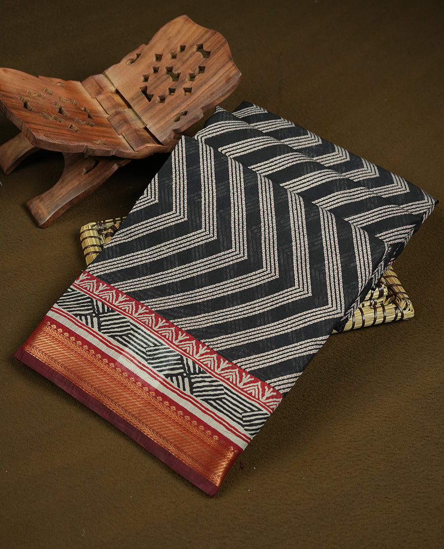 Black colour mixed chanderi cotton saree with ashy white zari body, red and black geometric pallu with floral motifs, gold border, and matching black blouse.