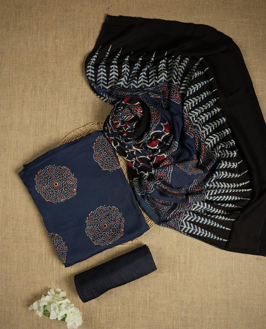 Navy blue suit material featuring intricate Ajrak inspired prints in maroon, blue, and off white & Includes a beautifully patterned dupatta and matching plain bottom.