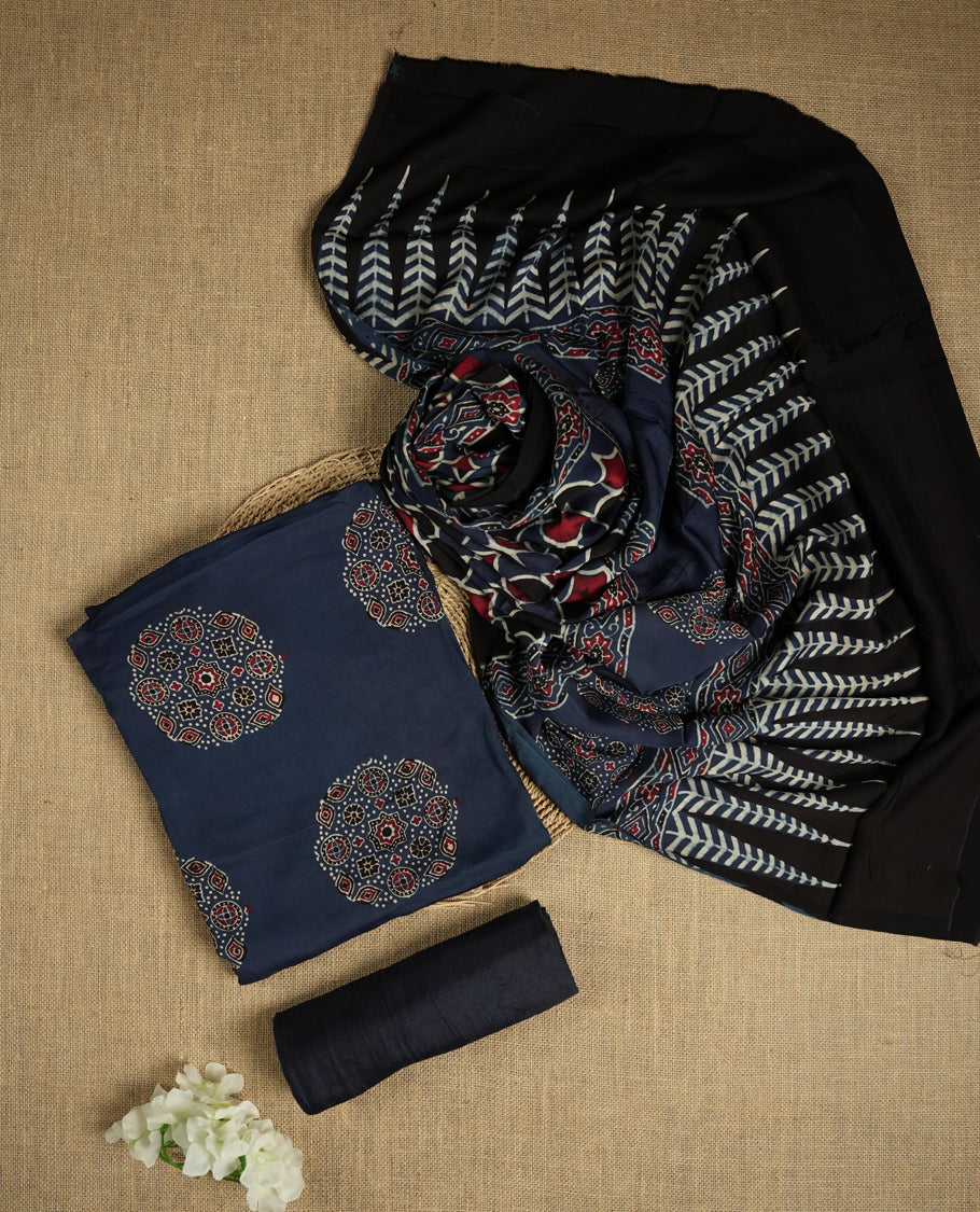 Navy blue suit material featuring intricate Ajrak inspired prints in maroon, blue, and off white & Includes a beautifully patterned dupatta and matching plain bottom.
