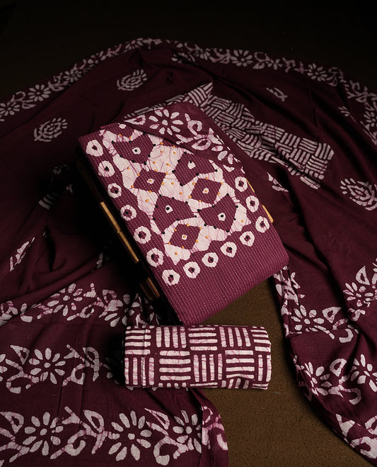 Wine & Off white cotton churidar material adorned with black & yellow colour thread work on the neckline, featuring traditional tie dye patterns and a stripped body & Comes with a matching printed dupatta and coordinated printed  bottom.