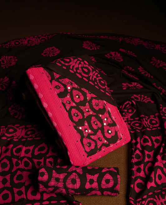 Black and magenta colour cotton churidar material featuring mirror work on the neckline with traditional tie dye patterns & Paired with a matching printed dupatta and coordinated printed fabric for the bottom.