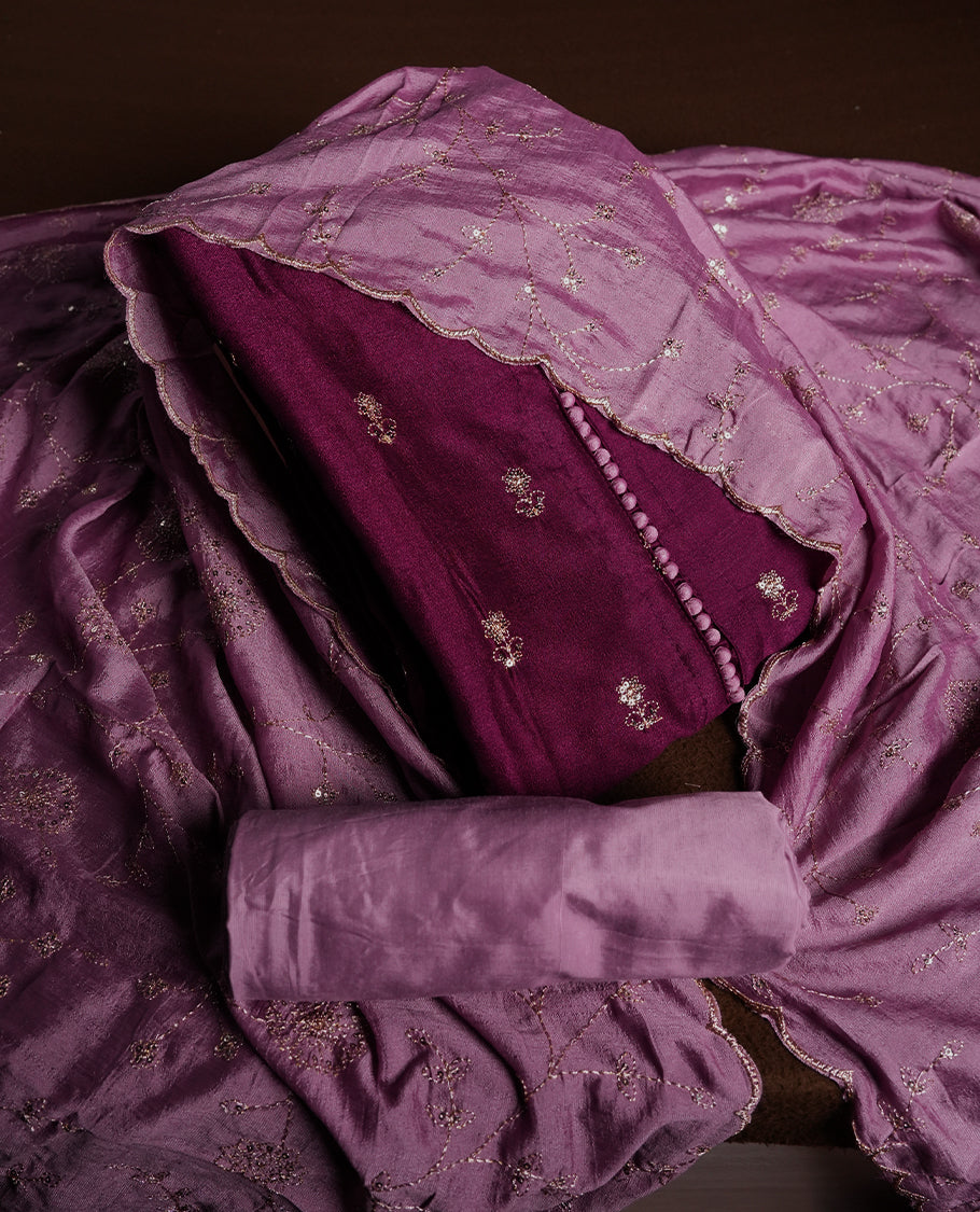 Magenta purple colour churidhar material featuring thread embroidery on the front panel, contrast lavender colour dupatta with elegant border, and matching plain bottom