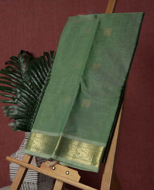 Mint Green colour Pure Kanchi cotton saree featuring delicate golden buttas and a rich zari border with intricate motifs & Paired with a matching blouse, it exudes timeless elegance, perfect for festive and traditional occasions.