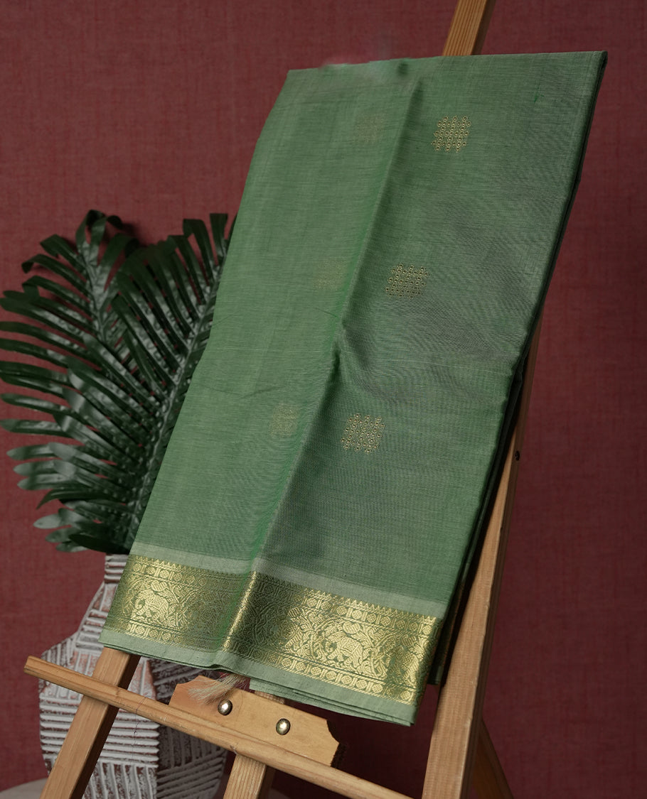 Mint Green colour Pure Kanchi cotton saree featuring delicate golden buttas and a rich zari border with intricate motifs & Paired with a matching blouse, it exudes timeless elegance, perfect for festive and traditional occasions.