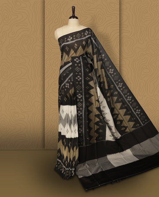 Black colour Ikkat Pochampally saree featuring bold geometric motifs in beige, white, and grey with a striking contrast border, beautifully blending tradition with elegance, Comes with matching blouse.