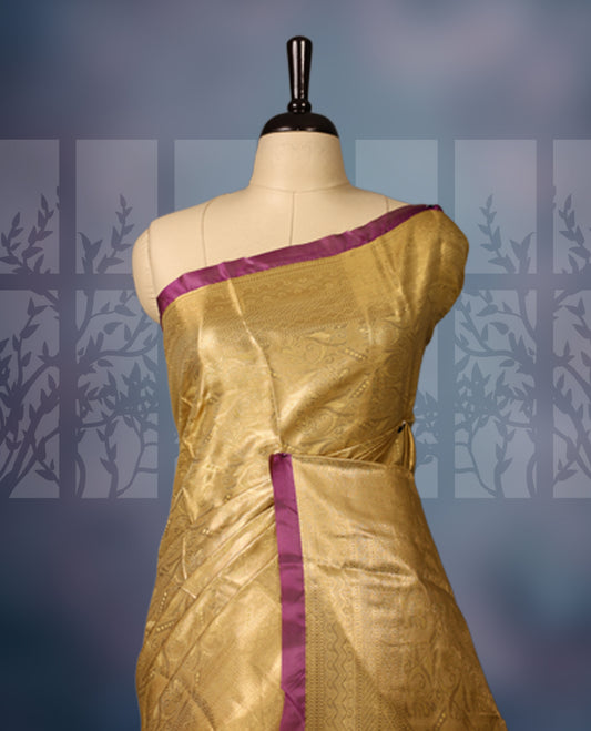 Golden semi silk brocade saree with intricate self brocade work across the body, paired with a rich contrast violet border and matching pallu. Includes a coordinating blouse for an elegant traditional look.