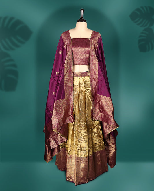 Regal semi stitched dhavani in rich maroon and antique gold silk, adorned with fine zari detailing, Ideal for festive occasions and traditional events.