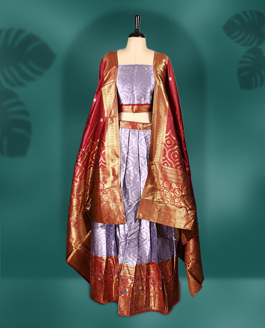 Charming Semi stitiched lavender and red Dhavani set featuring a lustrous lavender skirt with rich golden zari border, paired with a contrasting red dupatta detailed with golden motifs, perfect for festive and wedding occasions.