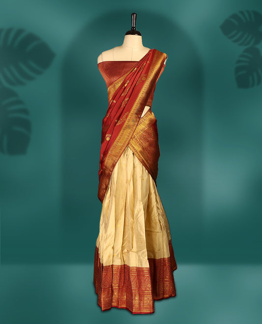 Traditional semi stitched dhavani in cream and rich maroon silk, highlighted with intricate zari motifs and border & A timeless piece ideal for weddings, festivals, and cultural celebrations.