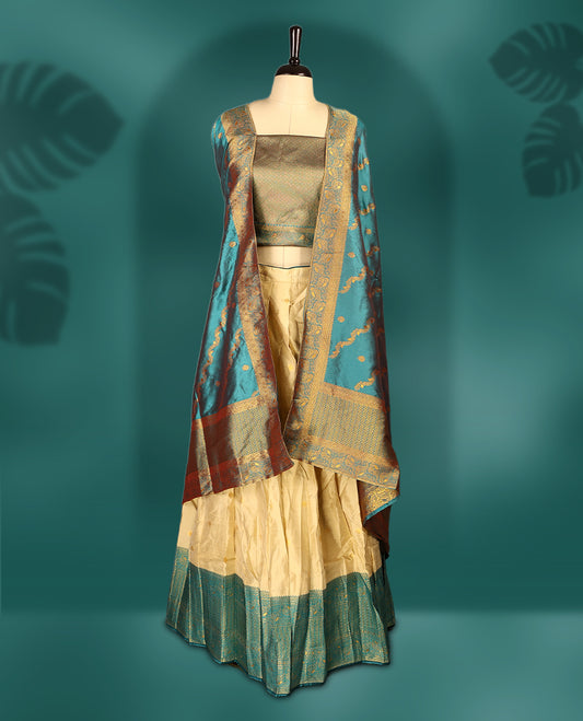 Chic semi stitched dhavani in cream and teal silk with delicate zari motifs and a rich pallu &  A perfect choice for traditional celebrations, blending elegance with customizable comfort and grace.