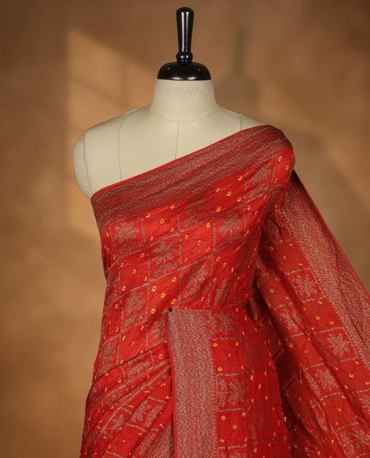 Reddish orange colour Banarasi Bandhani silk saree featuring with intricate Banarasi motifs on body, complemented by antique zari woven border and grand pallu, paired with matching  blouse