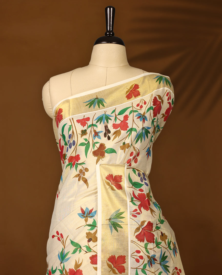 Elegent Off white colour cotton Kerala saree featuring vibrant multicolor floral prints all over the body, beautifully highlighted with a rich golden zari border paired with matching blouse.