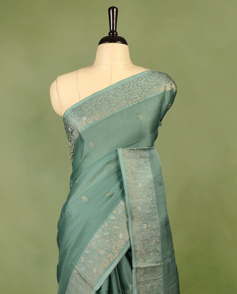 Pastel Green colour pure Banaras crepe saree showcases elegant Gold zari Flower Motifs all over the body, a traditional gold & Silver zari border, a rich intricately woven pallu, and comes with a matching blouse.