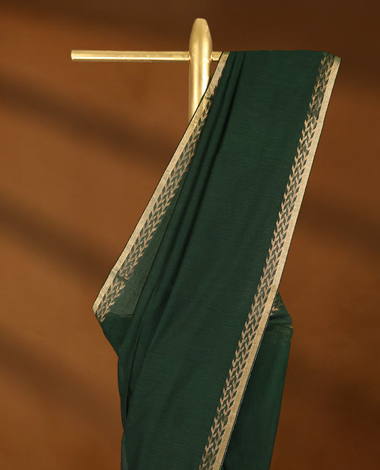 Bottle Green colour soft khadi cotton saree with plain body, detailed woven Gold zari border, paired pallu with tussles, with matching blouse.