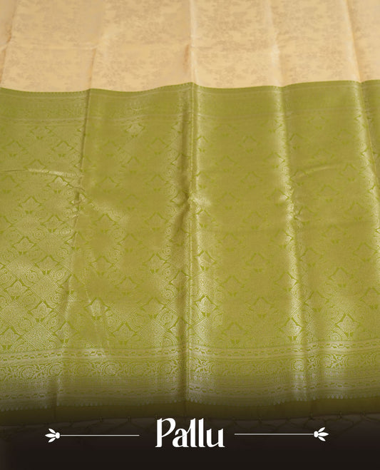 Light cream colour semi silk saree adorned with delicate golden zari buttas across the body, complemented by an elegant olive green pallu and matching border, and paired with a coordinated blouse piece
