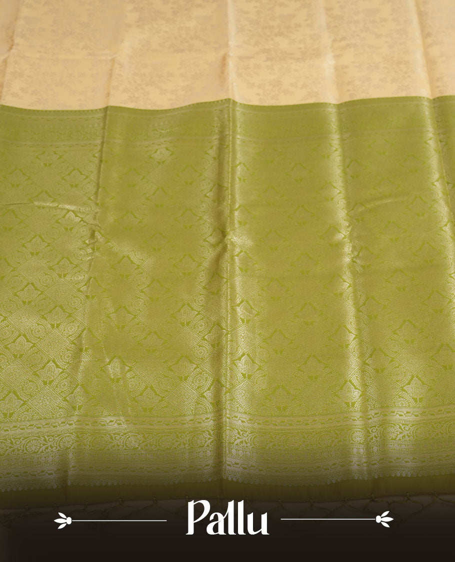 Light cream colour semi silk saree adorned with delicate golden zari buttas across the body, complemented by an elegant olive green pallu and matching border, and paired with a coordinated blouse piece