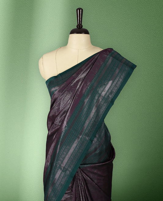 Deep Grape colour semi silk saree featuring neem zari floral kodi motifs all over the body, complemented by a rich green woven border with geometric detailing, with matching blouse.