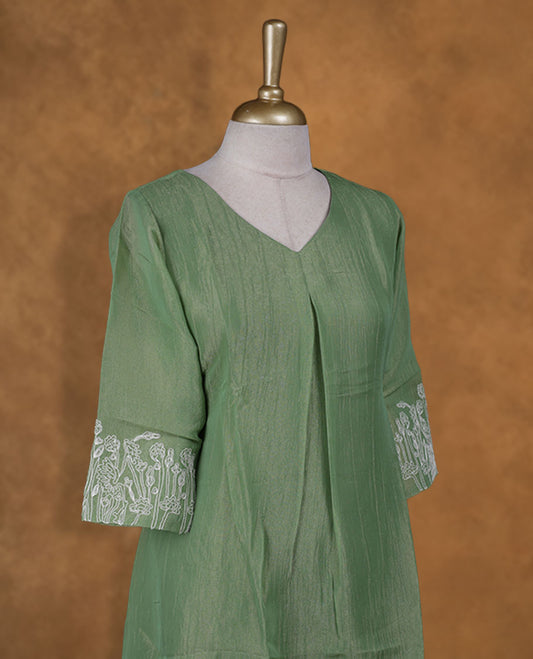 Pastel green and gold double shade colour kurti with white floral thread pattern on sleeve, knee length design, styled with a Round neckline.