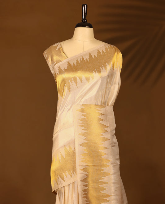 Ivory and gold soft tissue Kerala saree featuring a striking zigzag zari border with a matching blouse
