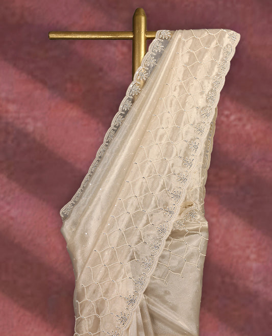 Beige colour pure organza saree featuring sequin work all over the body, adorned with a heavily embellished border with beads, stones, and sequins, complemented by a worked pallu and paired with a matching embellished blouse