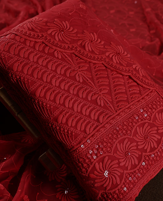 Stunning deep red churidhar material embellished with intricate floral embroidery and subtle sequin detailing, paired with a plain matching bottom and beautifully embroidered dupatta, ideal for festive and grand occasions.