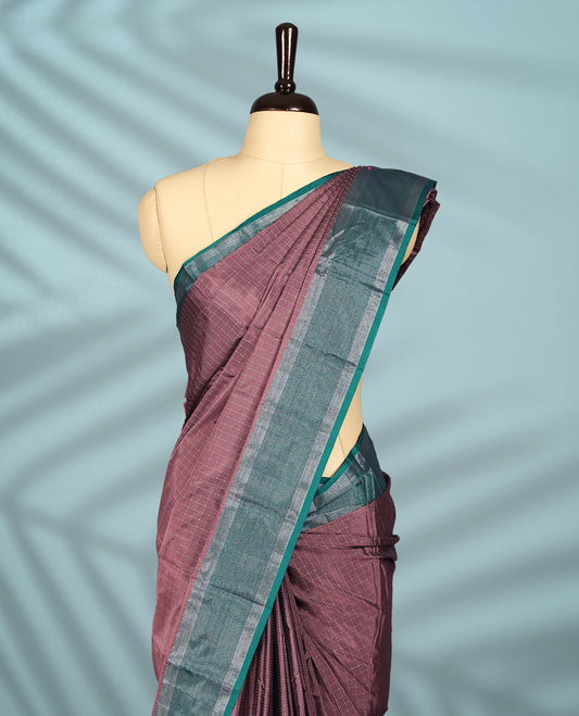 Pastel Brown colour body with delicate silver checks, paired with a contrasting green and silver zari border, comes with a matching blouse.